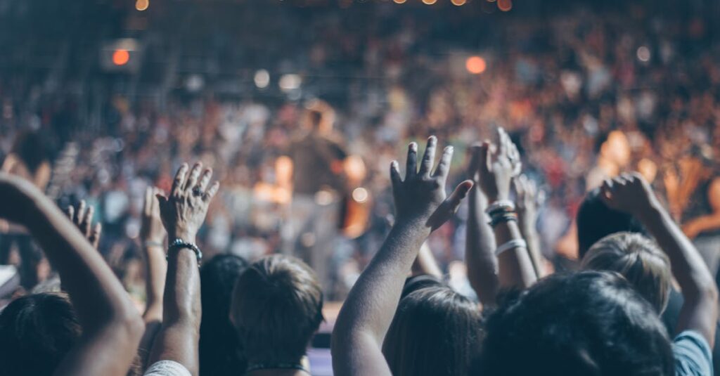 Group of People Raise Their Hands on Stadium